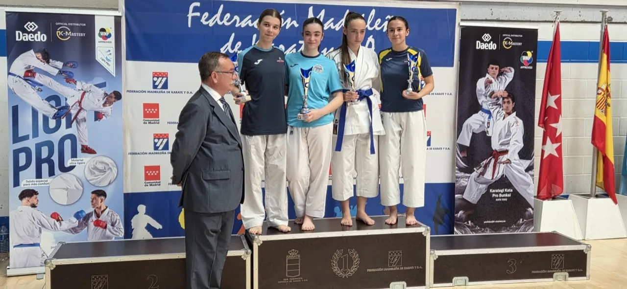 Competidoras de kumite con trofeos en el podio